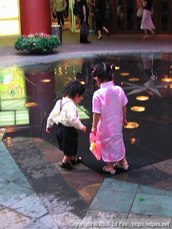 kids playing in a Canal City fountain, viewed from the back