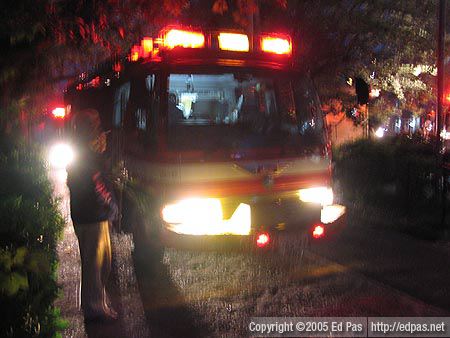 fire truck with a man standing in front of it enjoying a cigarette