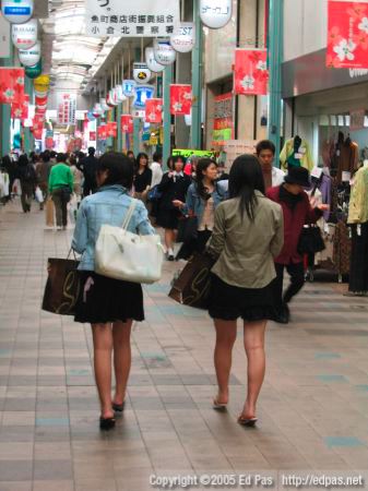 a view of the backs of two women walking through the Kokura arcades