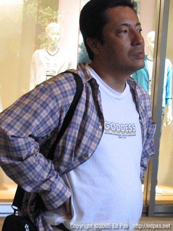 a nondescript middle-aged man in a shirt that says 'GODDESS'