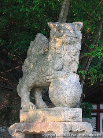 stone lion dog in shade, near the entrance to Itsukushima shrine