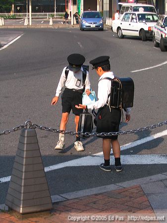 two schoolboys stomping a bug in front of Tobata Station