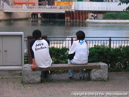 photo of a couple sitting on a bench in the park overlooking the Murasaki River in Kitakyushu