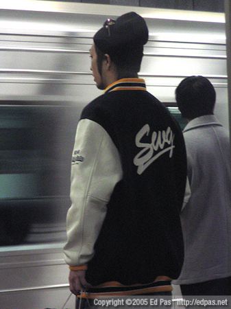 young man in SWG bomber jacket, on train platform at Hakata Station